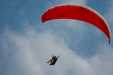 Paragliding flying in the blue sky.