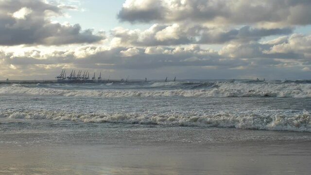 Heavy Waves on Baltic Sea Storm with Container Terminal Cranes in Background