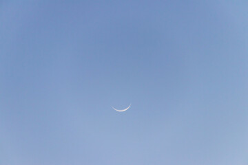 Crescent moon on blue sky. Look like a smile on a good day.