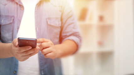 Closeup of mobile phone in business man hands. Young modern entrepreneur using smartphone. Communication concept