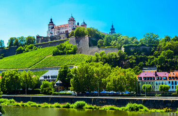 Fototapeta na wymiar The mighty fortress Marienberg is the symbol of Wurzburg. Festung Marienberg rises above the River Main and vineyards on the hillside. Germany,