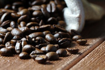 white cup and coffee beans scattered on wooden surface. food and beverage concept
