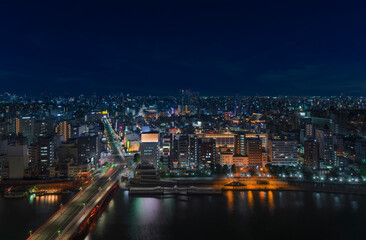 Obraz na płótnie Canvas Aerial nocturn panoramic view of the Azumabashi bridge on Sumida river leading to the illuminated buildings and skyscrapers of Asakusa in Tokyo.