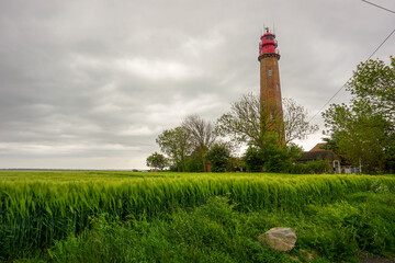 Fehmarn, Germany - 05/26/2020: The Lighthouse Of Fl&uuml;gge On The Isle Of Fehmarn With Plants In The Foreground