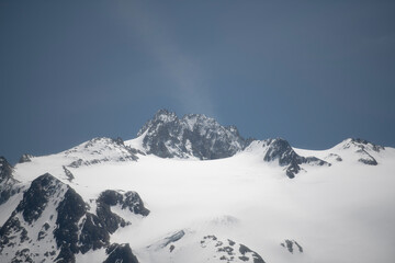 Fototapeta na wymiar Alpine mountains on a background of blue sky with clouds.