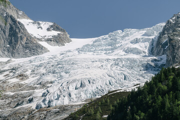 Alpine mountains and glacier on a background of blue sky.