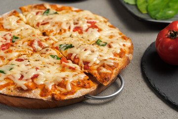 Vegetarian pizza near the ingredients on the concrete surface. Close up