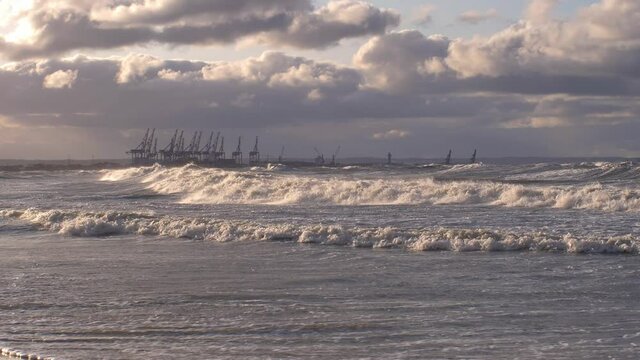 Heavy Waves on Baltic Sea Storm with Container Terminal Cranes in Background