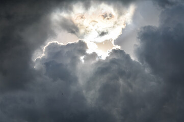 sunlight through very dark clouds background