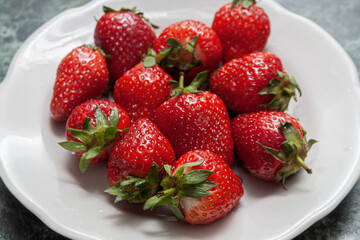 ripe strawberries on a white plate.