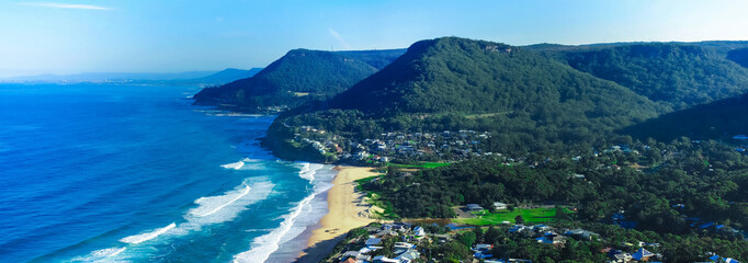 Panoramic view of Stanwell Park Beach Sydney Australia on a sunny winters day blue skies waves on the sand