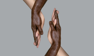 Two pairs of hands: the black male and white female hands touch palms, holding each other. The...