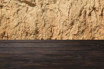 Wooden table against clay wall background. Mockup