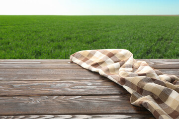 Wooden table with towel against field. Agriculture concept
