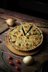 Homemade cheesy spinach quiche for brunch. set on wooden cafe table background.