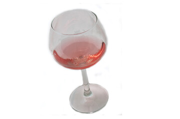 This single long stemmed glass has blush wine in a diagonal composition, isolated on a white background.