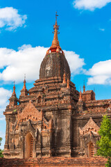 Fototapeta na wymiar View of a Majestic Ancient Pagoda in Bagan, Myanmar. Cloudy beautiful Sky, Copy Space, Vertical 