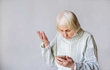 elderly woman senior pensioner sits with a gadget