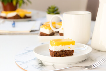 Layered cake with cocoa sponge cake, mascarpone cream and orange juice jelly on top