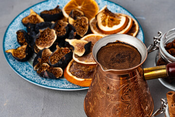 Copper turk with coffee and dried fruit pieces on table