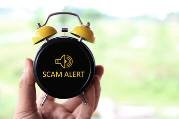 scammer alert concept on alarm clock