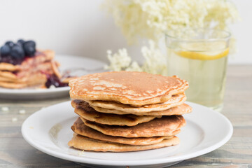 Stack of healthy oat pancakes with elder flower