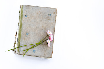 old book on a white background. Bouquet of flowers from daisies. Top view, place for text.