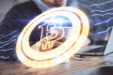 Crypto currency theme hologram with businessman working on computer on background. Concept of blockchain. Double exposure.