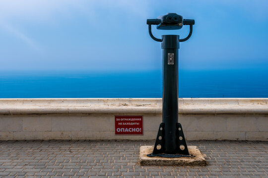 coin operated binoculars and blue sea background. Public panoramic binoculars to observe the sea view. Travel, relax or loneliness concept
