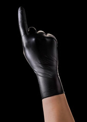 Hand in black gloves with the index finger pointing up on black