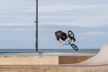 Bmx rider performing a jump on a skatepark.