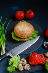 burger with fresh vegetables on a black background