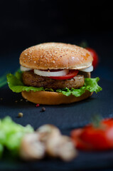burger with fresh vegetables on a black background