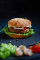 burger with fresh vegetables on a black background