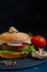 burger with fresh vegetables on a black background