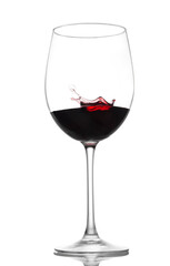 Glass of red wine with a splash on an isolated background