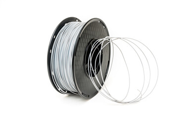 3D Printer Plastic Filament. Spool of grey thermoplastic wire for 3D printing close up isolated on...