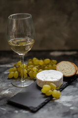 Camembert cheese with red caviar and white wine grapes