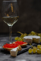 Camembert cheese with red caviar and white wine grapes