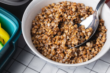 Cooked buckwheat in white bowl close up