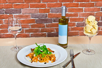 Pasta with shrimp and arugula. on a white plate. with a glass of water