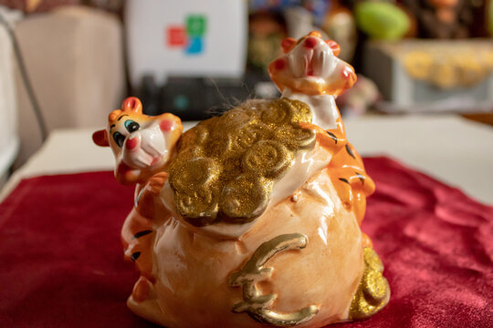 A children's toy made of porcelain material in the shape of a tiger cub guards a bag with gold and euros.