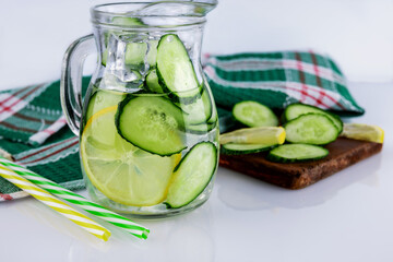 Drink cucumber with lemon, homemade lemonade in a decanter on a white background, malamyam depth of field, selective focus, concept of drink for health.