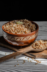 buckwheat porridge in a clay plate with butter and a wooden spoon