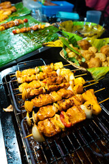Asian food. Different mini barbecue counter at night street food market.