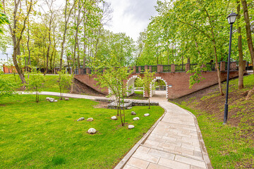 The ancient brick bridge pedestrian in the spring park and the peat bog