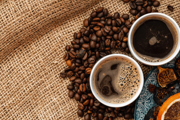 White coffee cup with roasted beans on sackcloth