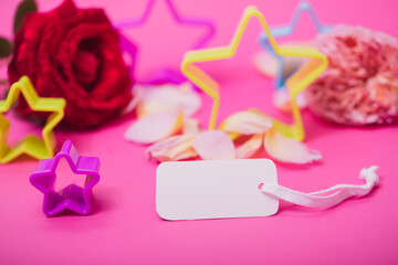 White empty card and stars on pink background. Greeting card festive holiday pastel backdrop. Birthday congratulations.