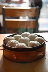 Chinese style minced pork steamed bun with steam smoke in bamboo basket