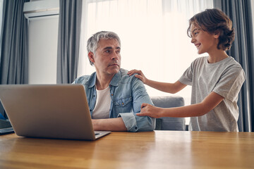 Little boy staying with his dad at home
